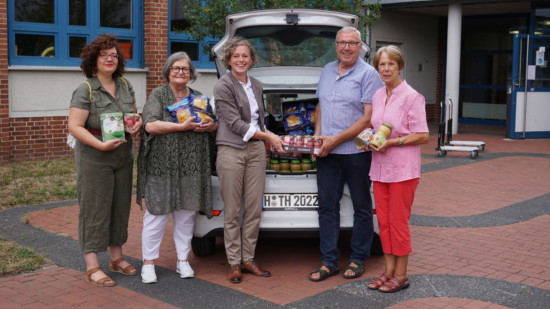 Franziska Greite-Schillert, Sonja Avemaria-Wrede, Thordies Hanisch, Reinhard Degotschin, Ursula Bauermeister vor einem Auto voll mit Lebensmittelspenden.